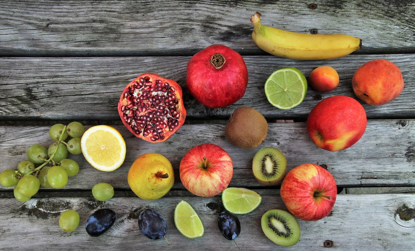 imagem com algumas frutas ricas em Vitamina C com laranja, romã, limão, kiwi...